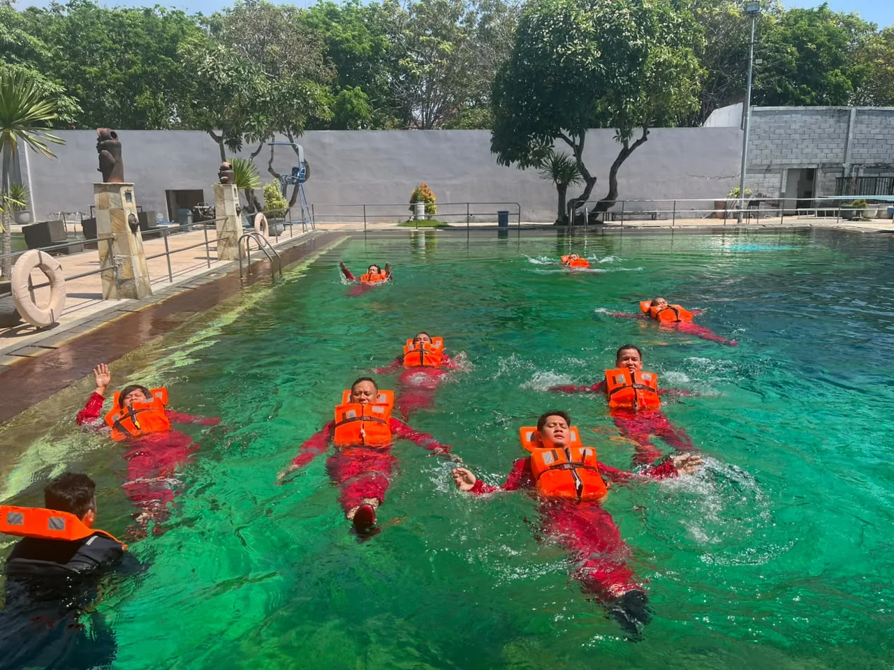 Peserta Basic Sea Survival berlatih mengapung berkelompok menggunakan life jacket di kolam