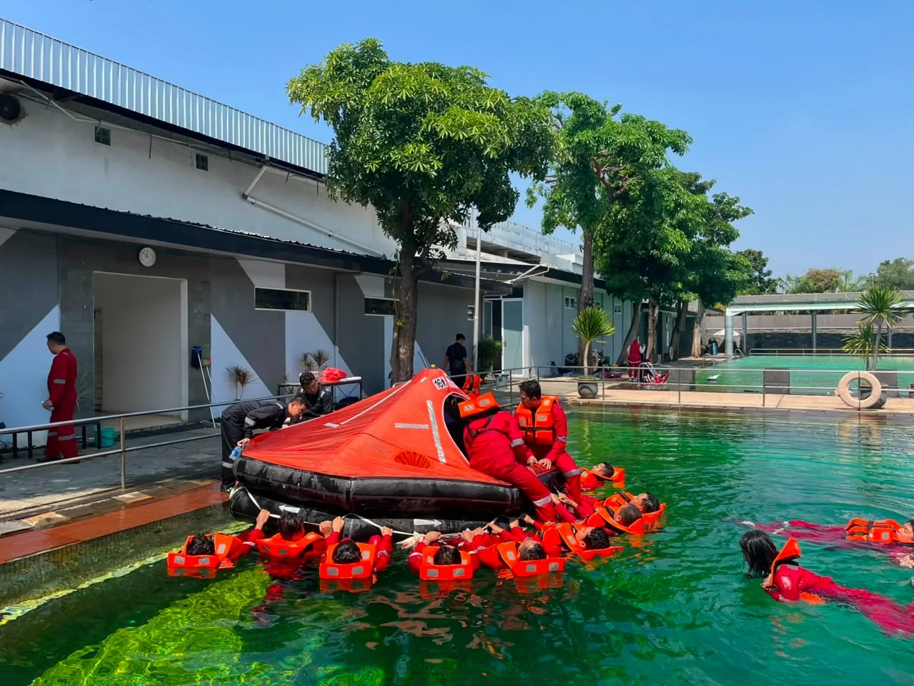 Peserta Basic Sea Survival berlatih naik ke life raft di kolam menggunakan life jacket